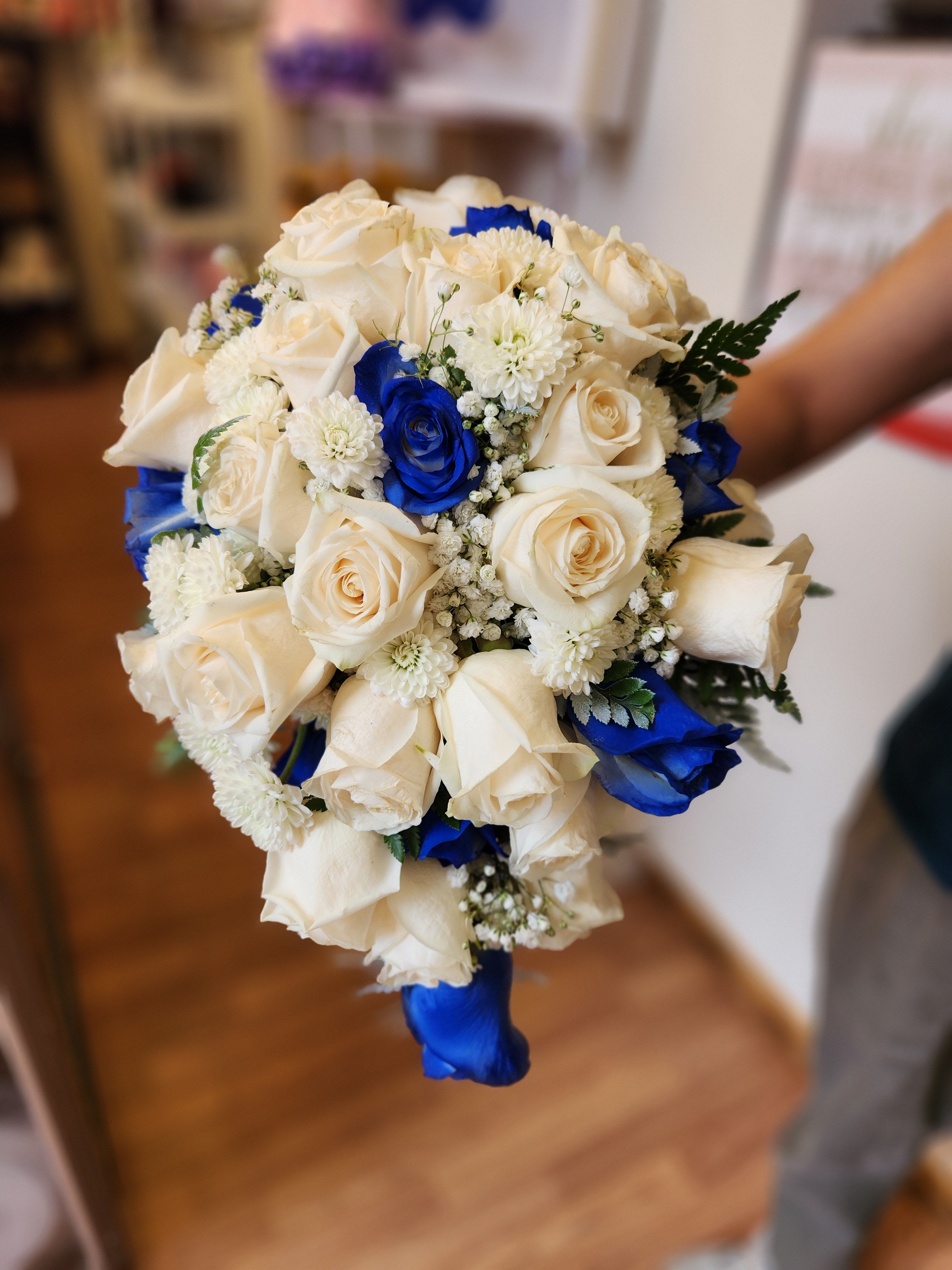 Bouquet of white and blue roses with small white filler flowers