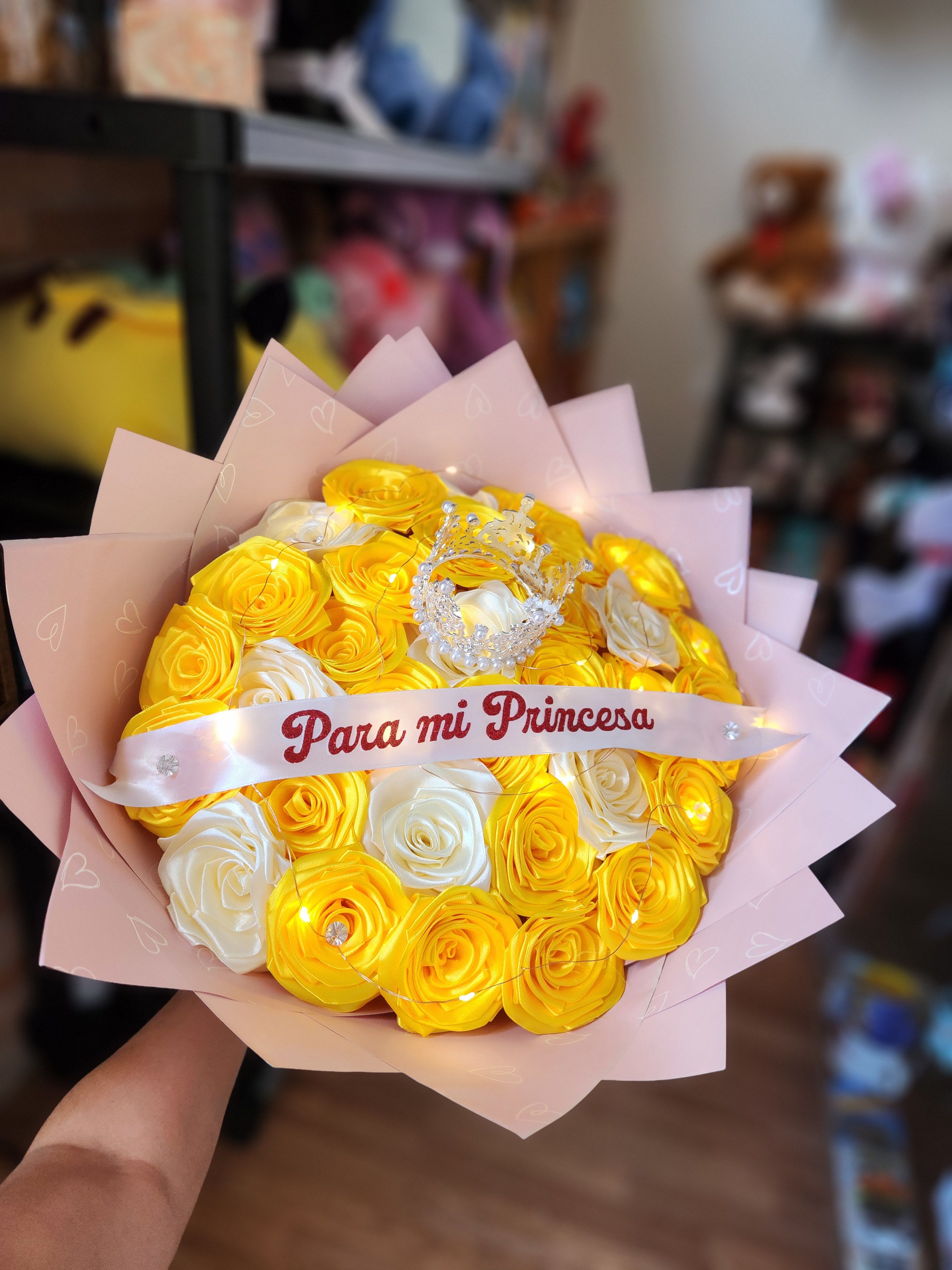 Yellow and white rose bouquet with a pink ribbon and crown topper