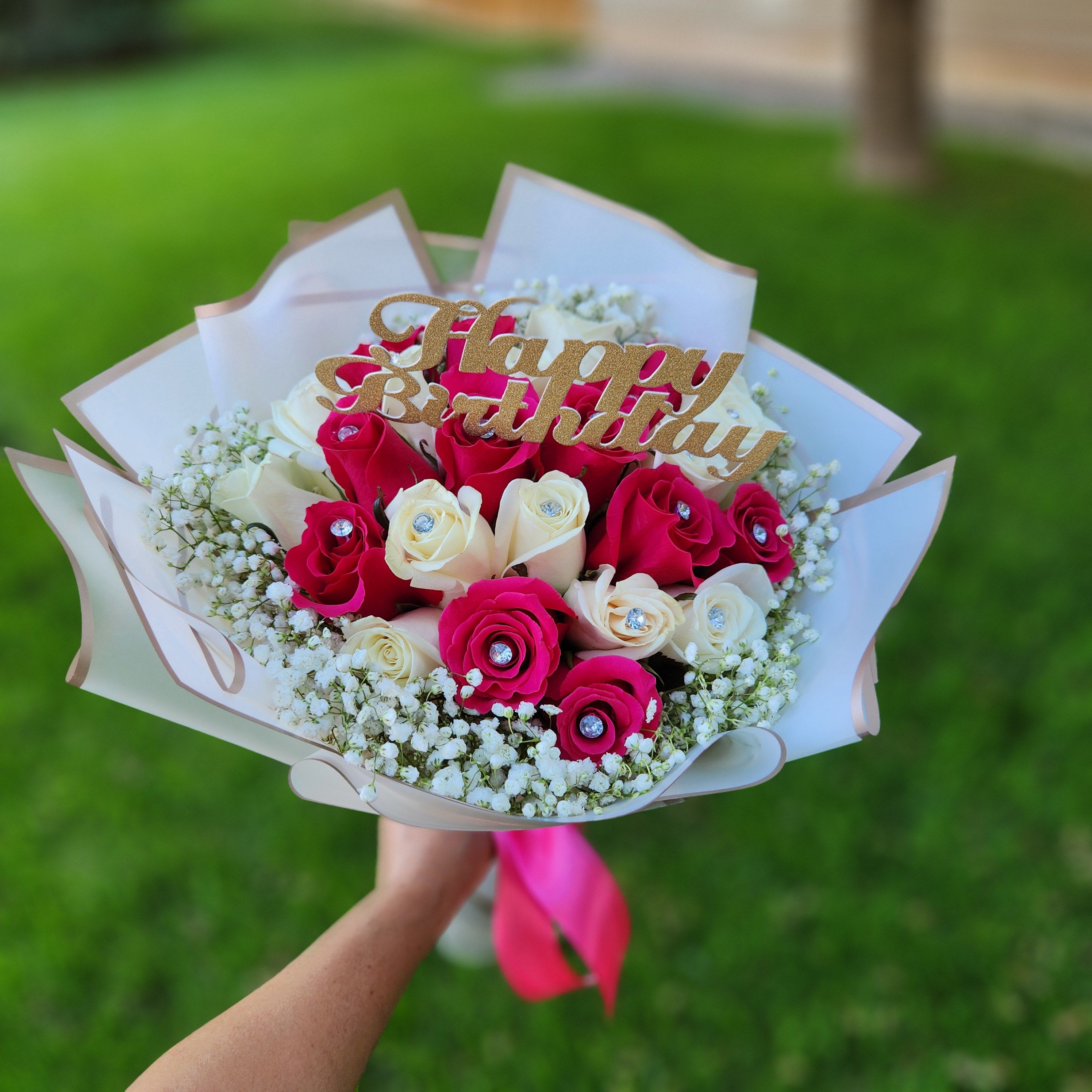 Bouquet of pink and white roses with a Happy Birthday topper