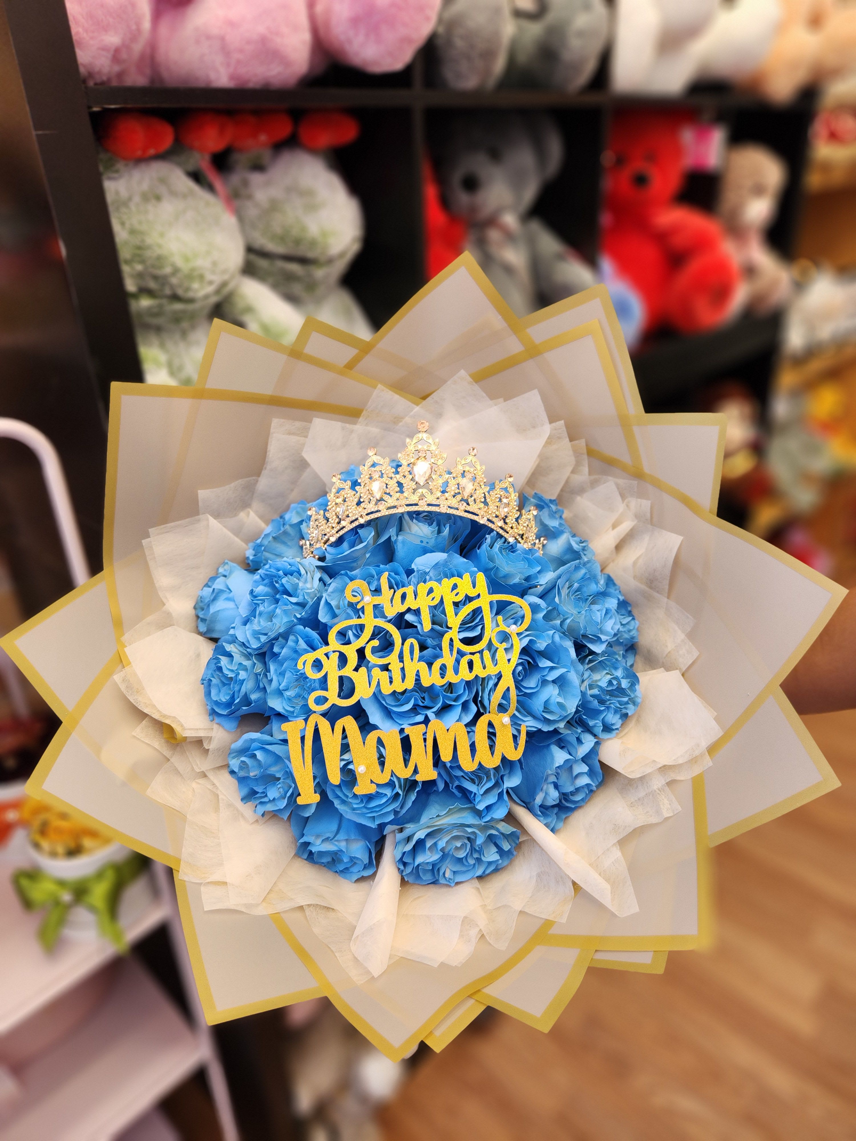 Blue rose bouquet with a gold birthday topper and crown