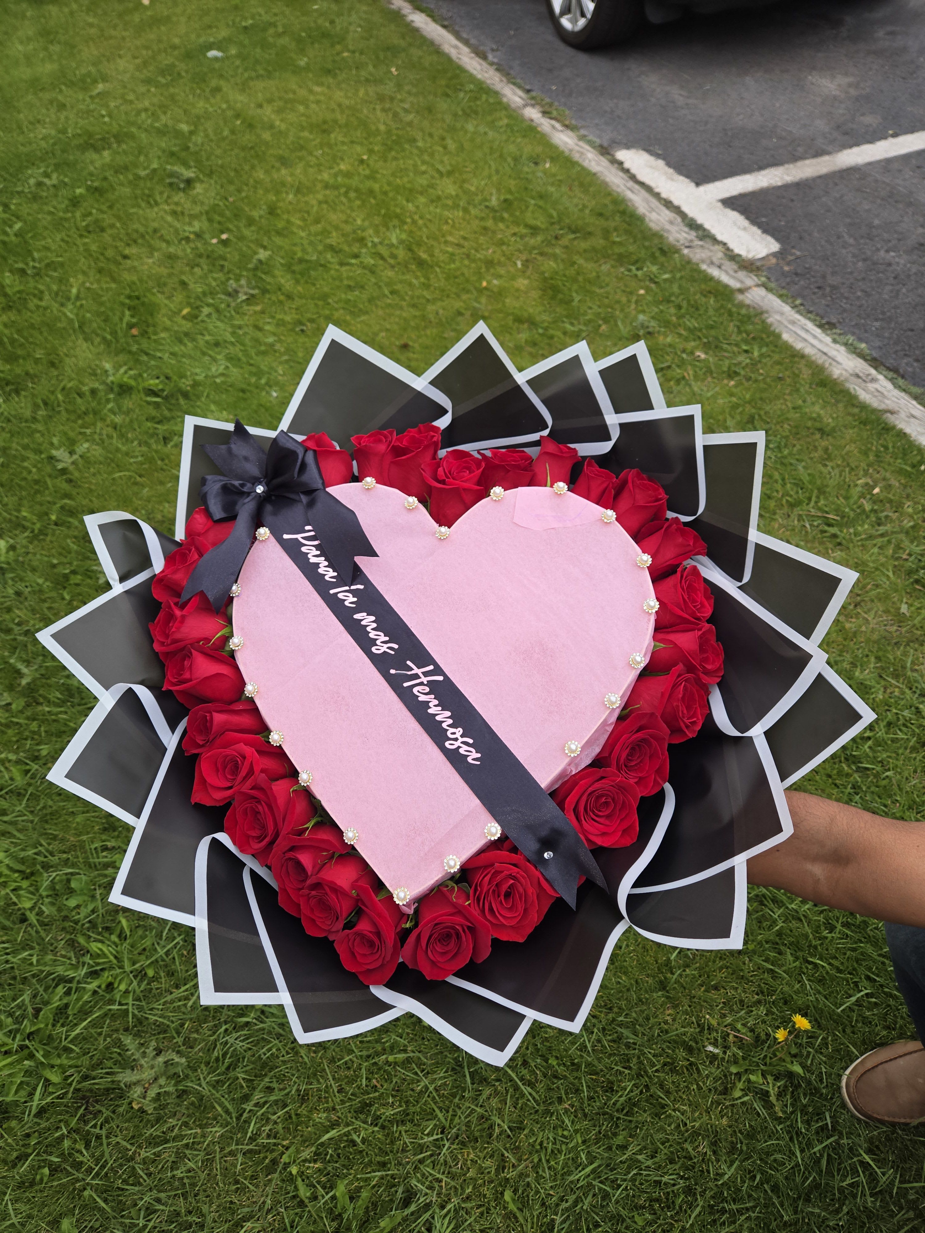 Heart-shaped rose bouquet with pink center and black wrapping