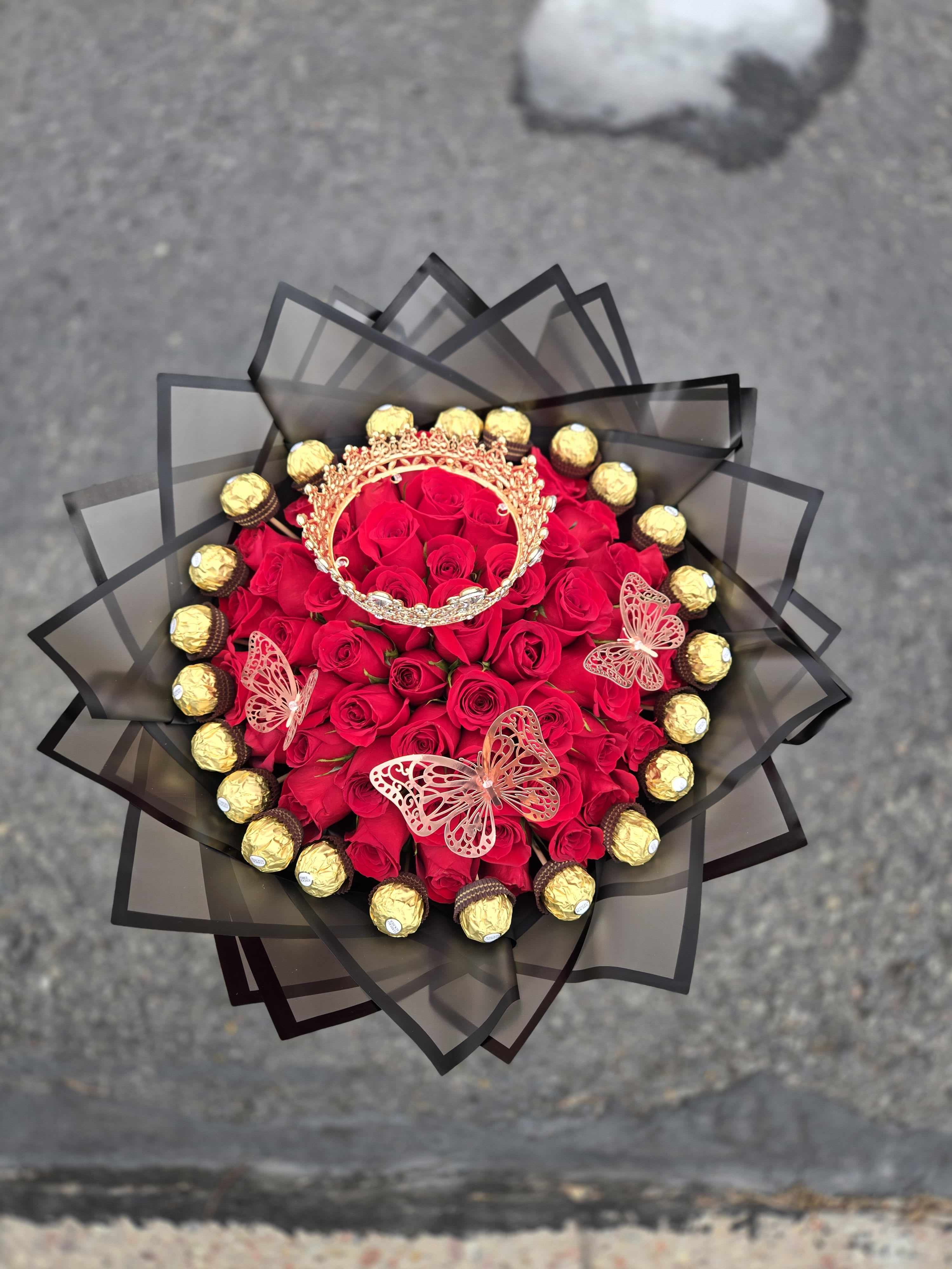 Bouquet of red roses with gold chocolates and butterfly decorations