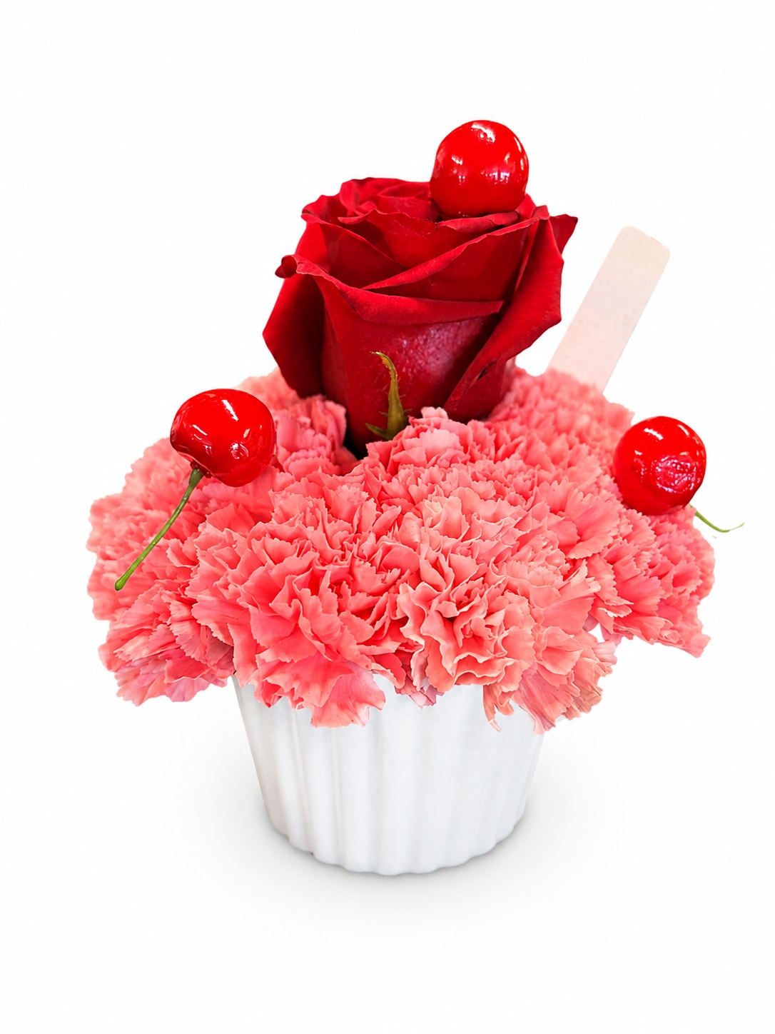 Pink carnations in a white cup with a red rose and cherries