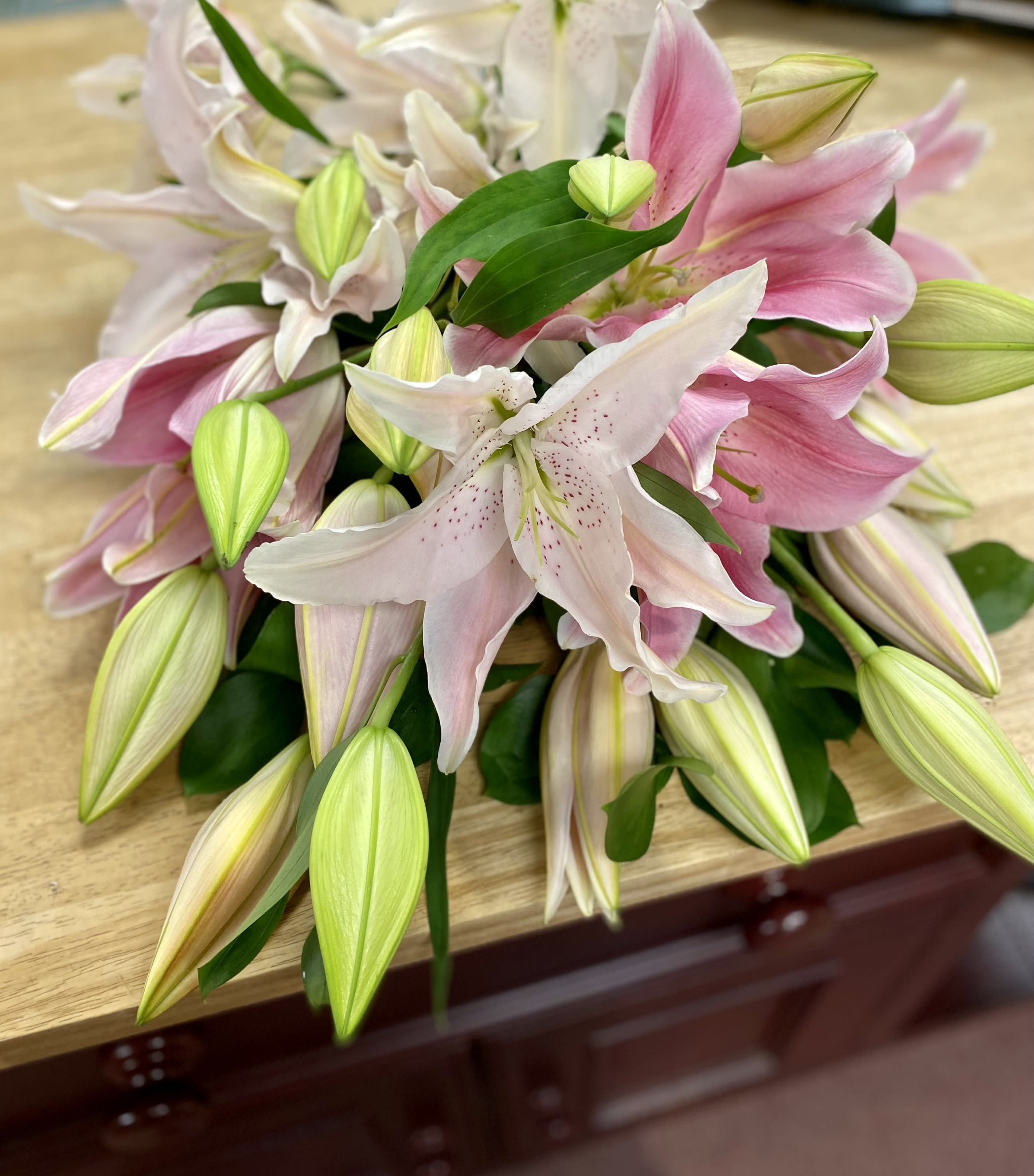 Pink and white lilies arranged in a bouquet on a table