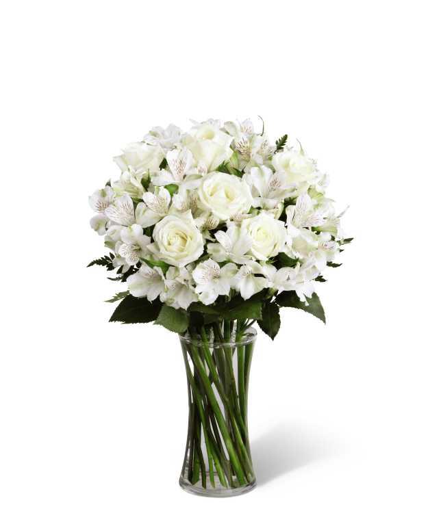 Cherished Friend Bouquet - The Cherished Friend Bouquet offers comfort and sympathy in the time of grief and loss. Bright white roses and Peruvian lilies are accented by lush greens and gorgeously arranged in a clear glass gathering vase to create a bouquet that will bring peace and show how much you care.