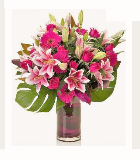 Pink lilies and gerbera daisies in a glass vase