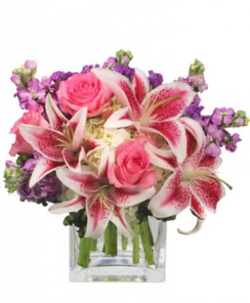 Pink roses and stargazer lilies in a clear glass vase