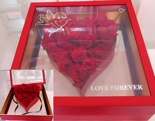 Red roses arranged in a heart-shaped gift box with a clear lid