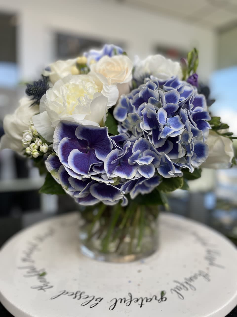 Blue and white bouquet in a clear glass vase