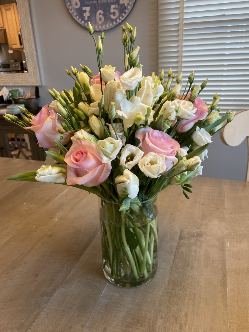 Pink and white flowers arranged in a clear glass vase
