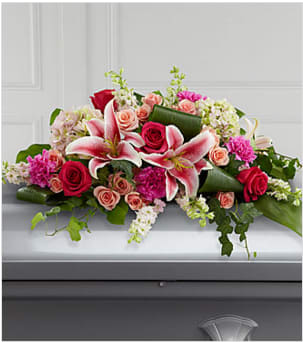 The FTD® Splendid Grace™ Casket Spray - An extraordinary way to pay your respects to someone very close, this colorful mixed flower casket spray beautifully delivers your sincere expression of love and sympathy. Traditionally ordered by the deceased's immediate family, this casket enhancement handcrafted by a local FTD artisan florist, includes larkspur, roses, carnations, hydrangeas and Stargazer lilies complemented with lush greens including aspidistra, salal and ivy vines. It is made to fit over the closed portion of a casket cover during visitation at a funeral home, at a funeral service and at a graveside ceremony at the cemetery. Your purchase includes a complimentary personalized gift message.