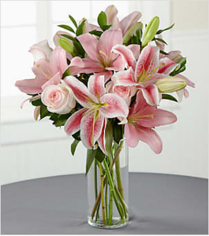 The FTD® Always &amp; Forever™ Bouquet - Like a lovely floral "hug", this blushing bouquet delivers your sincerest condolences in a way that is sure to comfort the pain of loss. Simple and beautiful, this composition handcrafted by an FTD artisan florist of pink roses and pink Asiatic lilies enhanced with lush greens is arranged in a clear glass cylinder vase. It makes an excellent choice for expressing your sympathy at a wake, for the funeral service or to console family and friends at home.  Your purchase includes a complimentary personalized gift message.