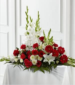 The FTD® Crimson &amp; White™ Arrangement - The FTD® Crimson &amp; White™ Arrangement is a lovely symbol of peace and love. Red roses, carnations and gerbera daisies pop against the white blooms of gladiolus, snapdragons, Oriental lilies and chrysanthemums. Accented with a variety of lush, vibrant greens, this exquisite arrangement is a beautiful tribute to the deceased. Approximately 30"H x 40"W. Your purchase includes a complimentary personalized gift message.