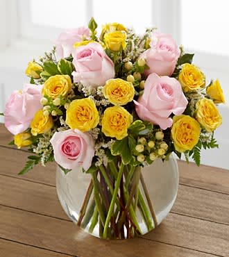Pink and yellow rose bouquet in a clear glass vase