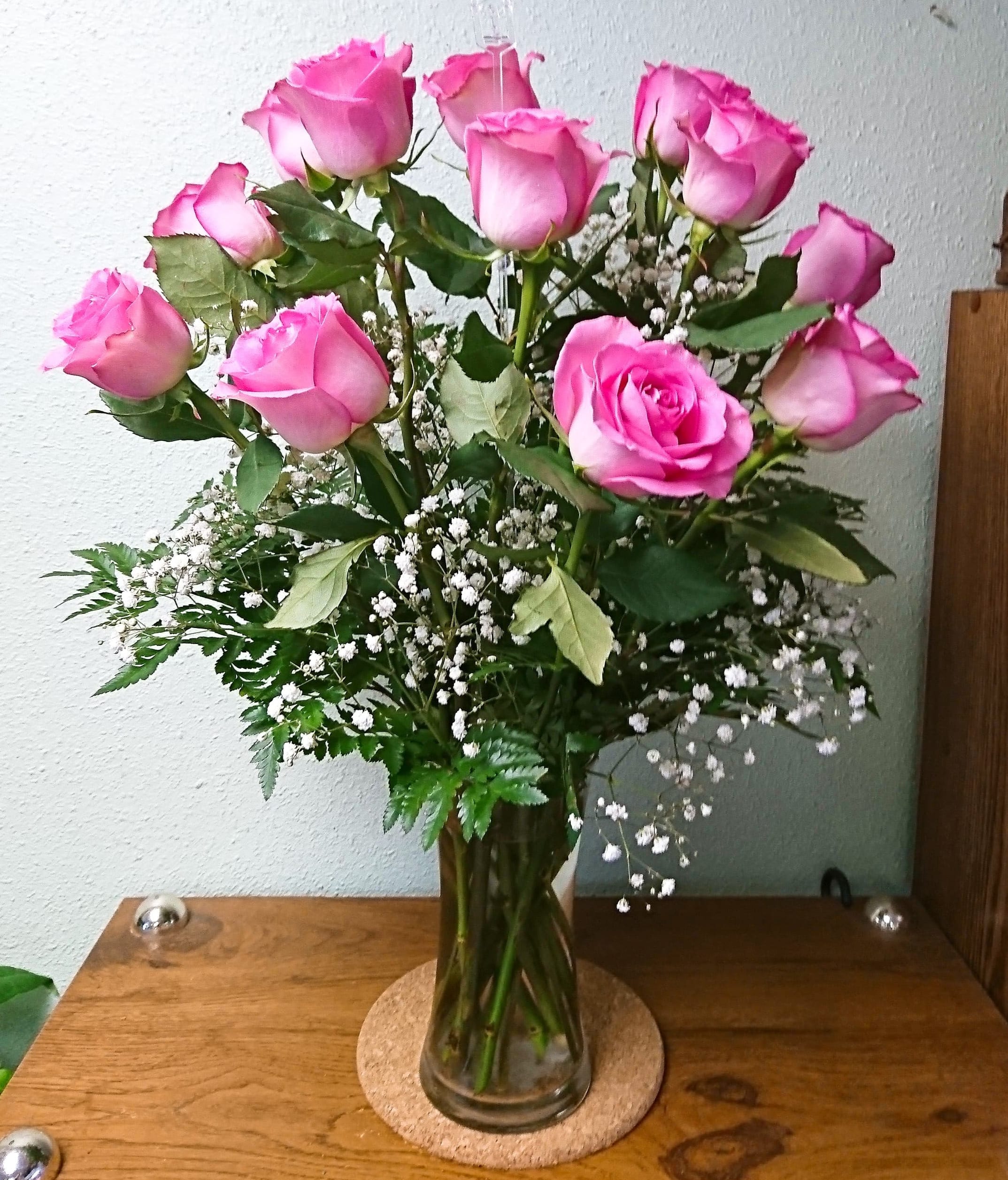 The Pink Rose Bouquet - Sweet and charming, our Pink Roses Bouquet features lovely pink roses arranged in a vase with fresh greenery and delicate baby's breath. A perfect expression of admiration, joy, or affection.  The STANDARD version includes 12 roses.  The DELUXE version includes 18 roses.  The PREMIUM version includes 24 roses. 