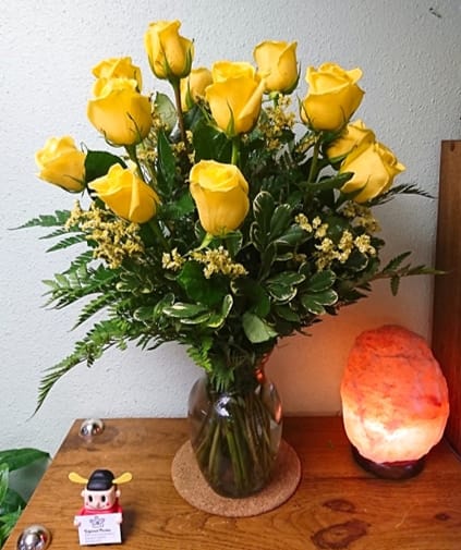 The Yellow Rose Bouquet - Bright and cheerful, our Yellow Roses Bouquet features vibrant yellow roses arranged in a vase with lush greenery and soft baby's breath. A joyful way to celebrate friendship and warmth.  The STANDARD version includes 12 roses. The DELUXE version includes 18 roses. The PREMIUM version includes 24 roses.