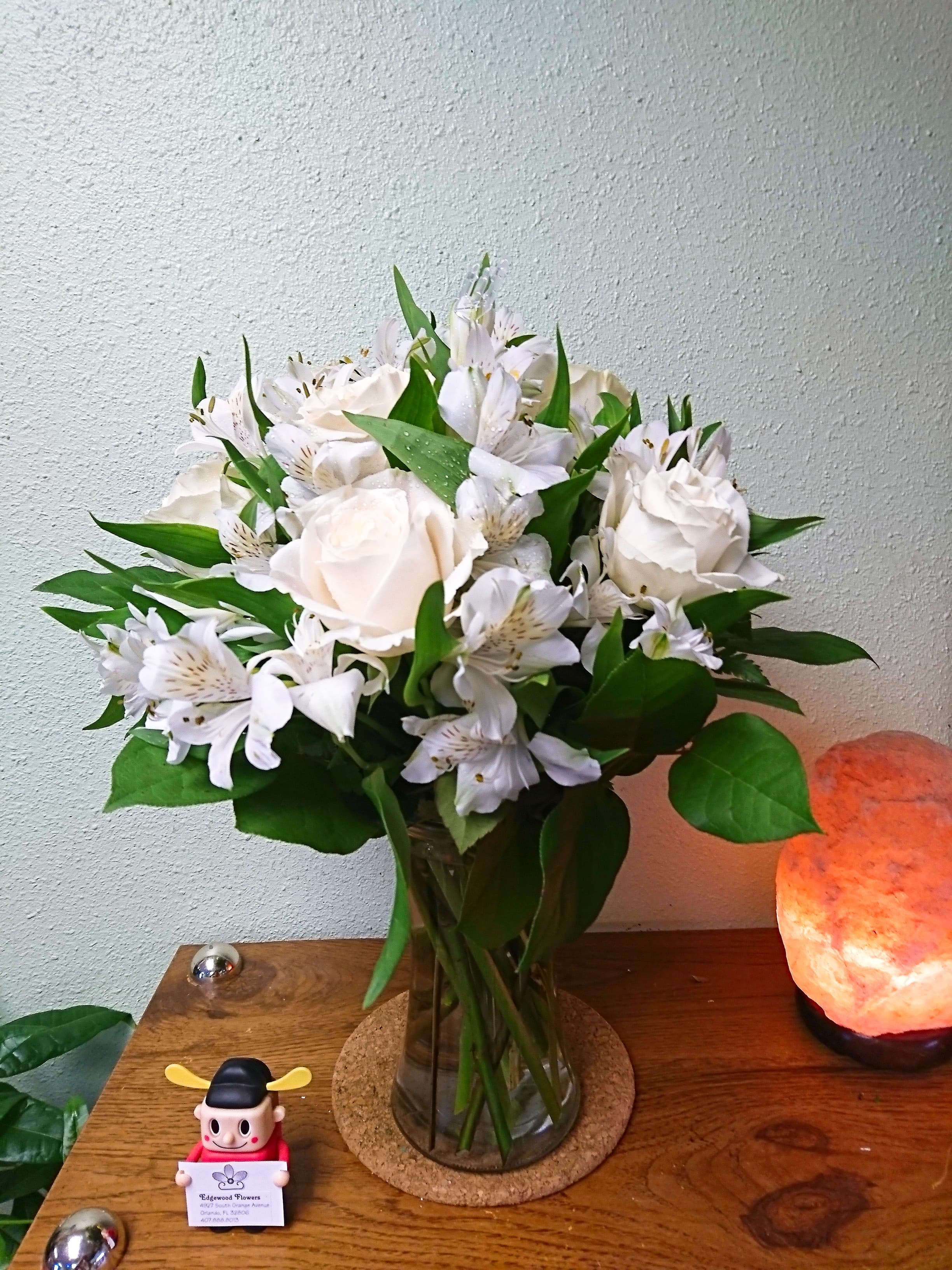 Cherished Friend Bouquet - The Cherished Friend Bouquet offers comfort and sympathy in the time of grief and loss. Bright white roses and Peruvian lilies are accented by lush greens and gorgeously arranged in a clear glass gathering vase to create a bouquet that will bring peace and show how much you care.    Approximate dimensions are 18"h x 12"w.
