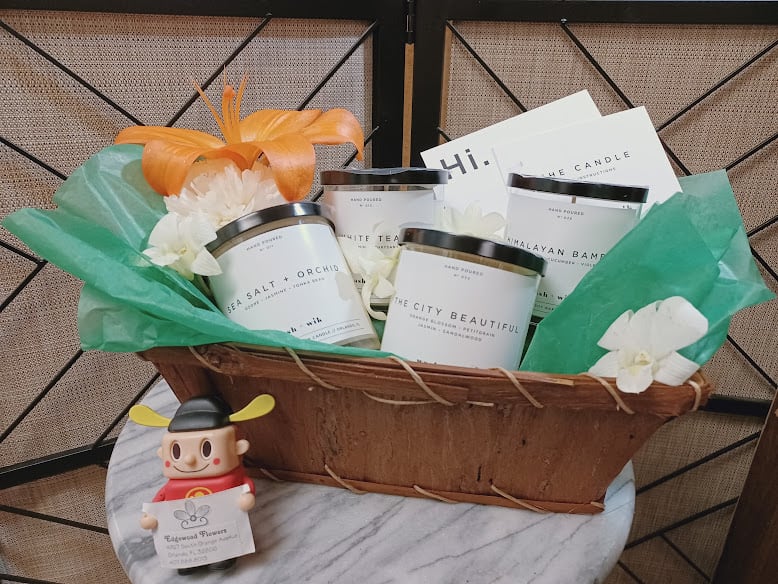 Gift basket with candles, white flowers, and a small figurine