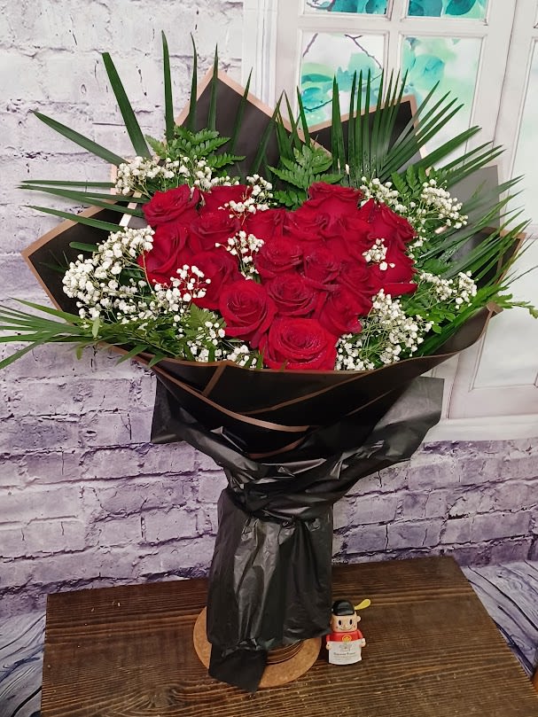 Bouquet of red roses with white baby's breath in black wrap