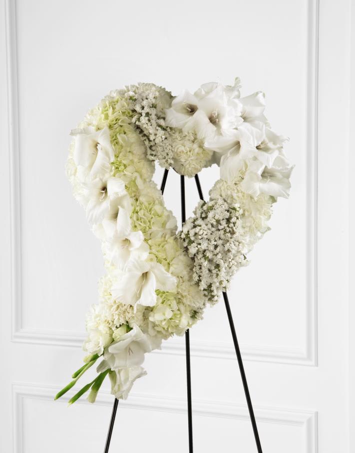 FTD Hearts Eternal Easel - "The FTD Hearts Eternal Easel is an exquisite way to show your love and affection for the deceased. White gladiolus, hydrangea, statice, mini carnations and carnations are beautifully arranged into the shape of a heart and displayed on a wire easel to offer elegant sophistication at their final farewell service.  25""h x 16""w "