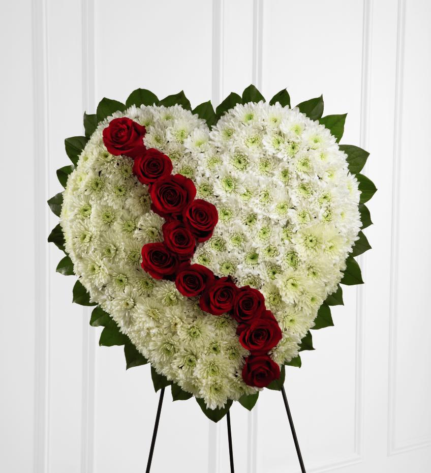 FTD Broken Heart - The FTD Broken Heart is a beautiful way to express the impact that the departed had on your life. Pearly white chrysanthemums form the shape of a heart, accented with greens lined around the outside and ""broken"" in the middle with a line of rich red roses to create an exquisite way to honor the life of the deceased at their memorial service. Displayed on a wire easel.   22""h x 22""w