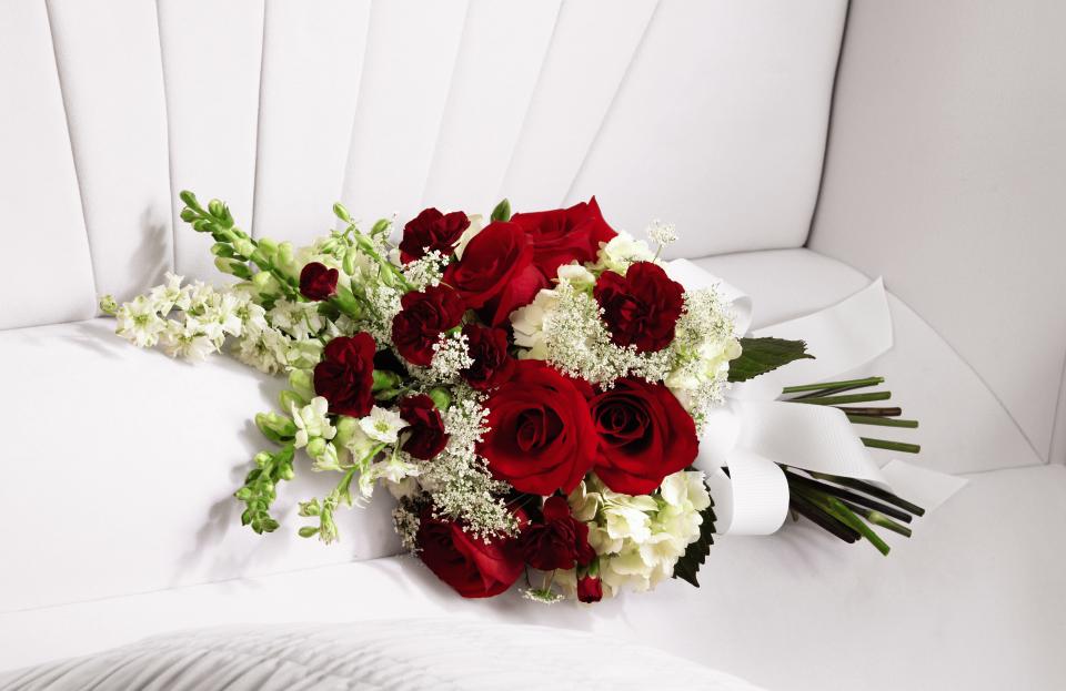 FTD Forever in our Hearts casket adornment - The FTD Forever in Our Hearts Casket Adornment is a beautiful  accent piece that adds that extra touch of elegance to their final  farewell service. Red roses and mini carnations are eye-catching and  bright arranged amongst white hydrangea, larkspur, snapdragons and Queen  Anne's Lace. Tied together with a white grosgrain ribbon, this gorgeous  bouquet is a lovely way to say goodbye to your beloved.    20""h x 10""w "