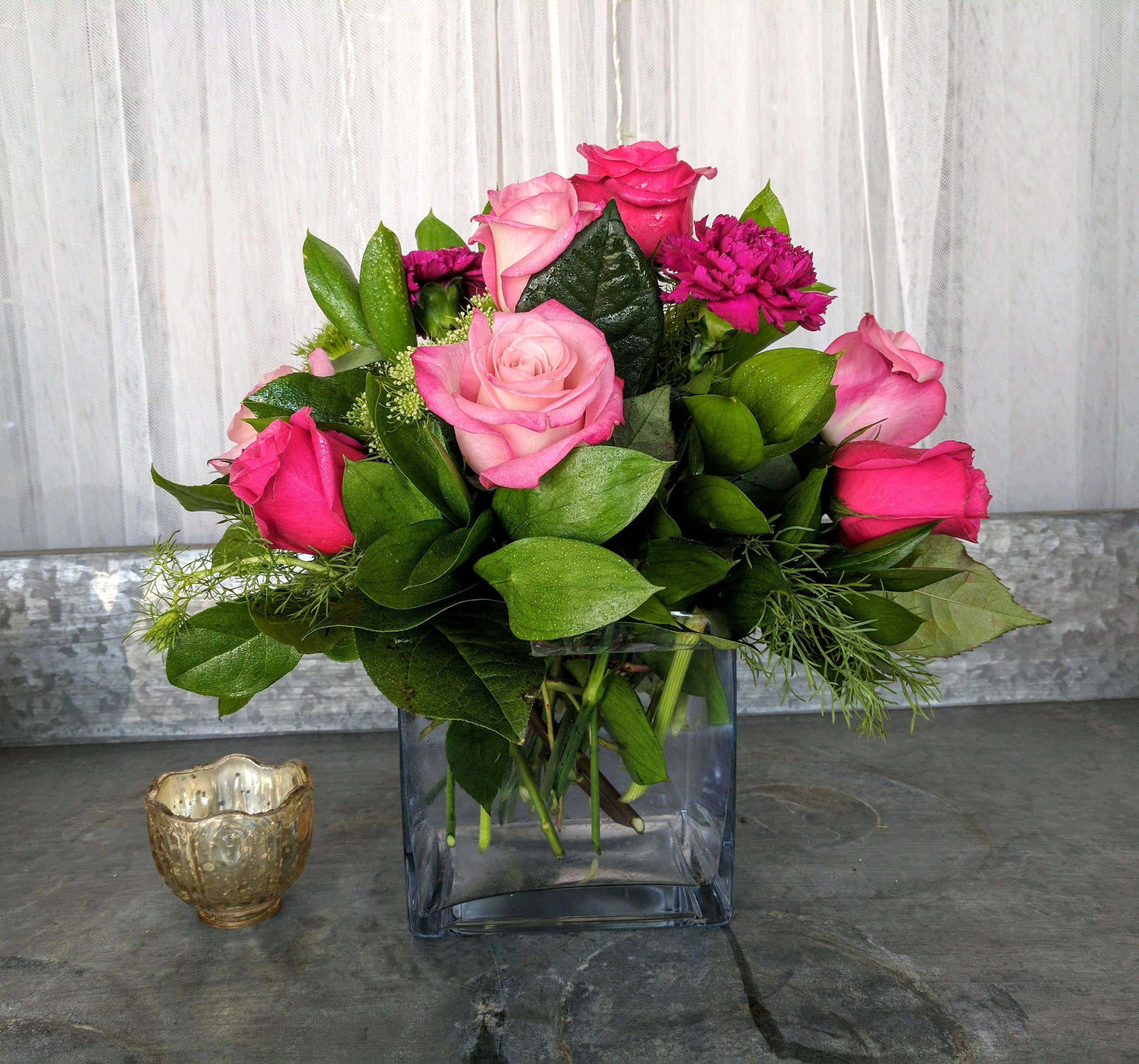 Elegant Rose Cube - A beautiful cube filled with pink Roses, Moon Vista Carnations and adorned with elegant Queen Anne's Lace or similar flowers surrounded by lush green foliage. (this arrangement goes nicely with the Elegant Tribute Wreath)
