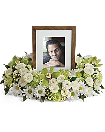 White floral arrangement surrounding a framed photo