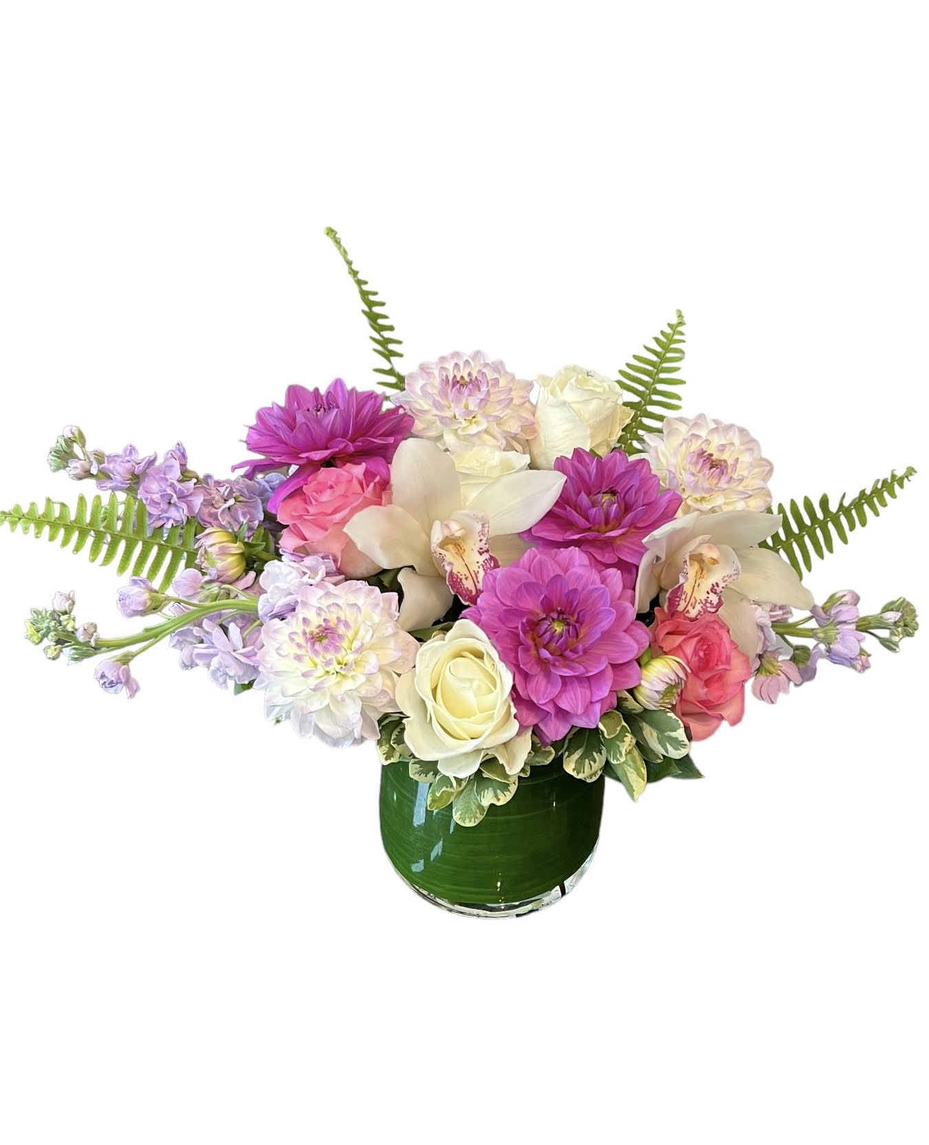 Summer Dreams - Purple and white dahlias, white cymbidium orchids, pink roses, white roses, stock, fern and greens designed in a clear glass vase, As shown in photo.