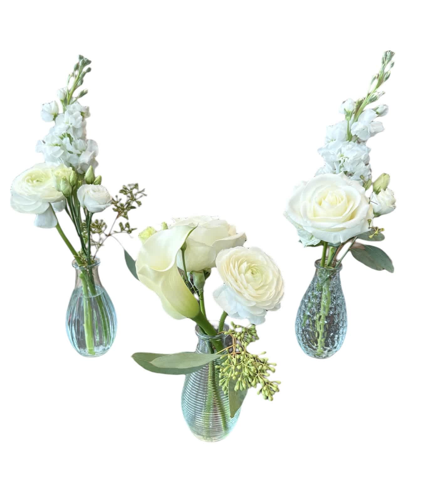 Three white floral arrangements in blue glass vases