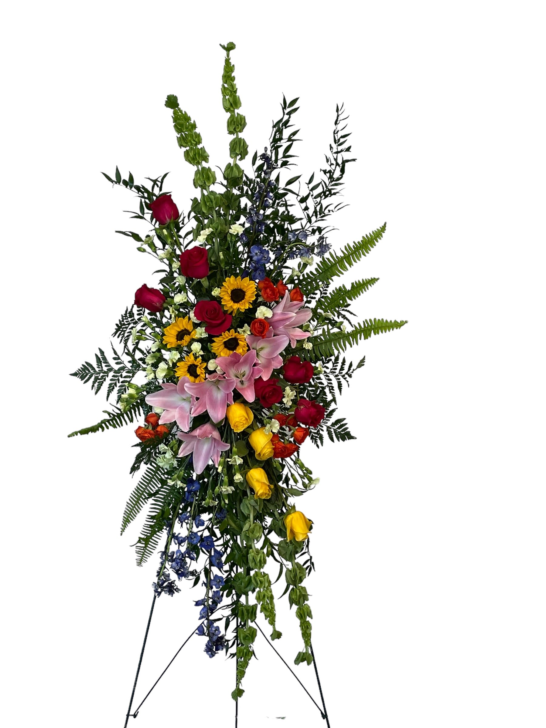 Tall standing floral spray with roses, lilies, sunflowers, and blue accents