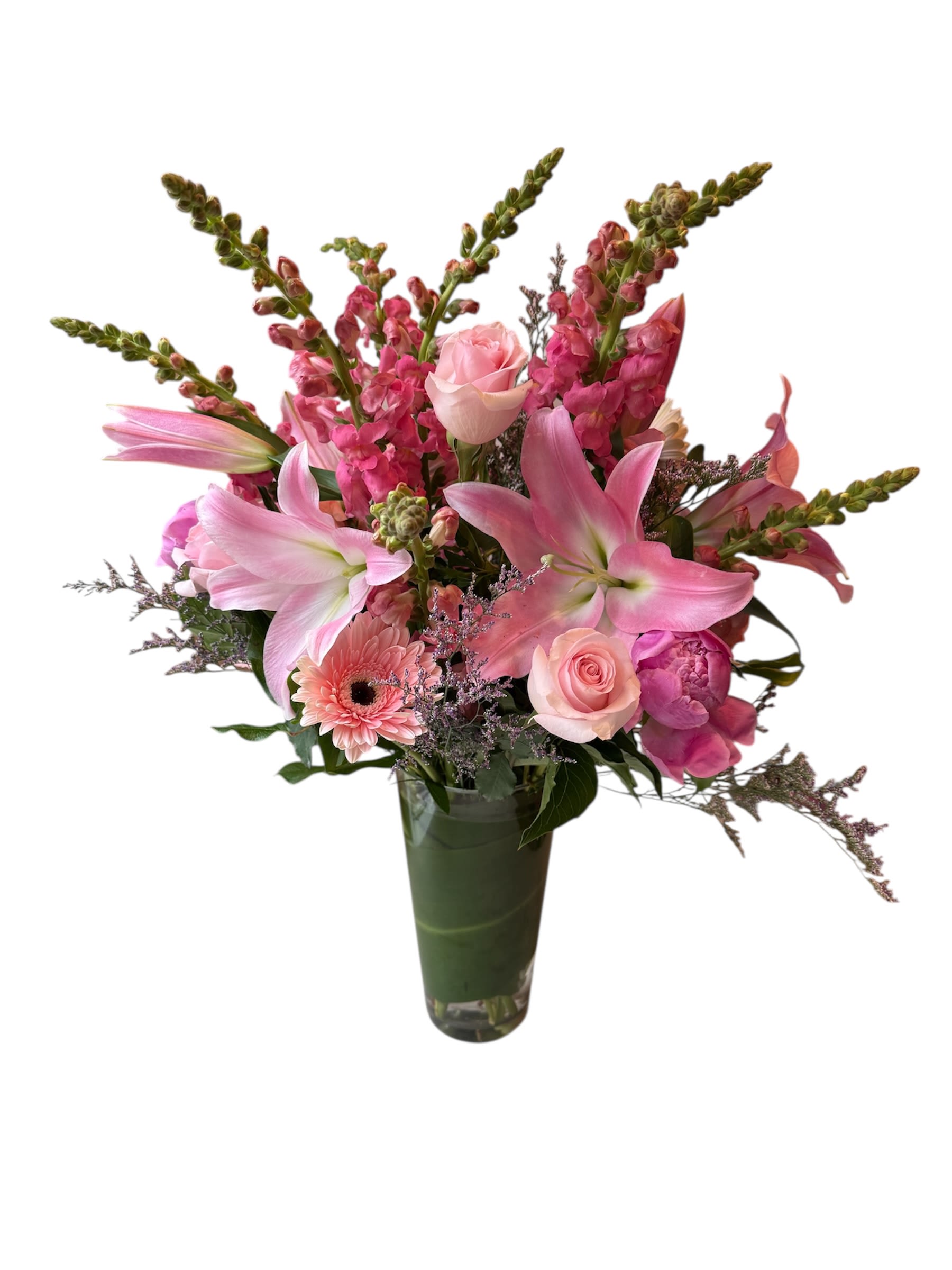 Pink lilies, roses, and snapdragons arranged in a tall glass vase