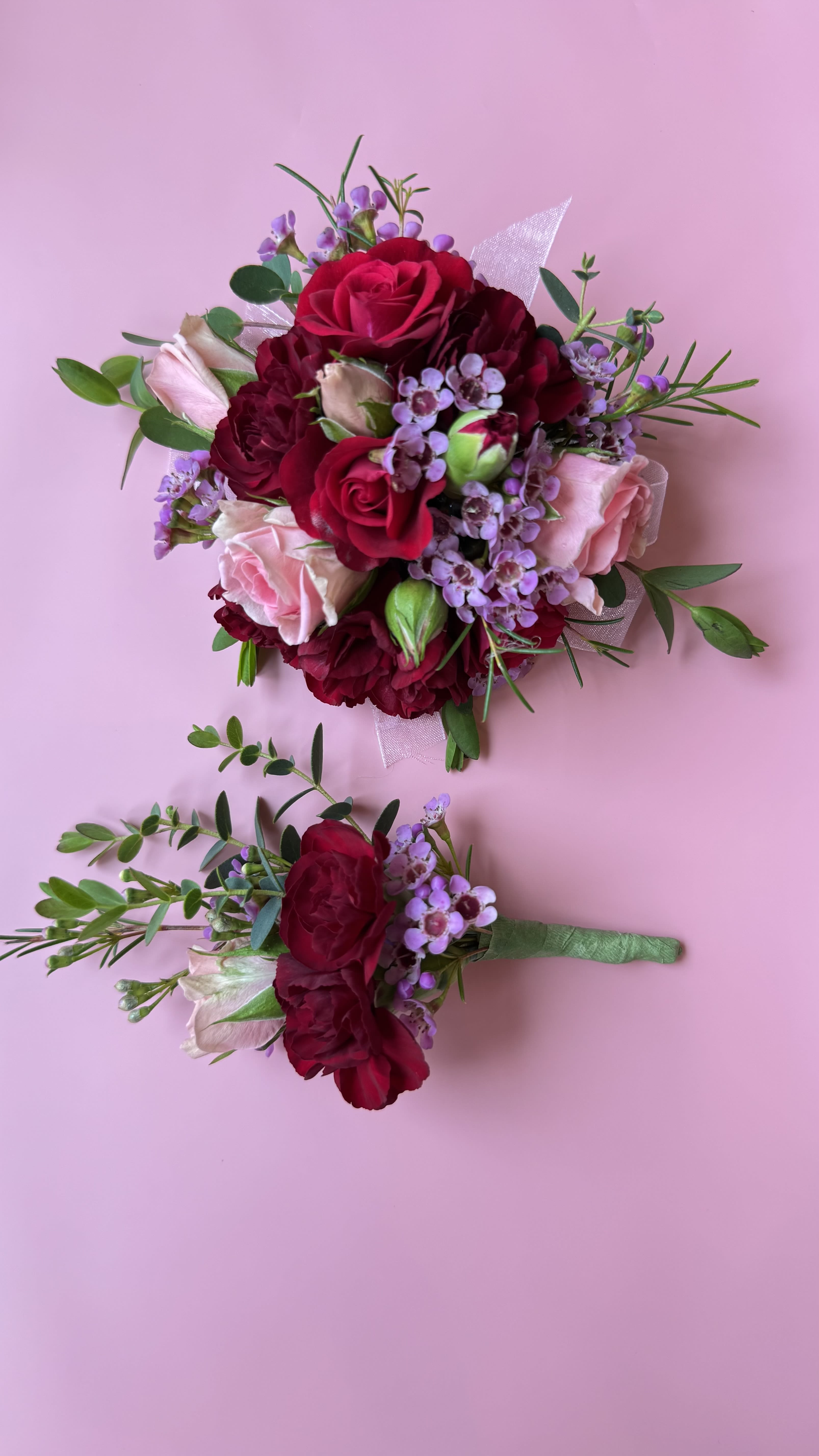 Two small floral bouquets with red and pink roses on a pink background
