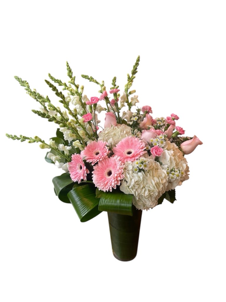 Tall pink and white flower arrangement with gerbera daisies and hydrangeas in a green-wrapped vase