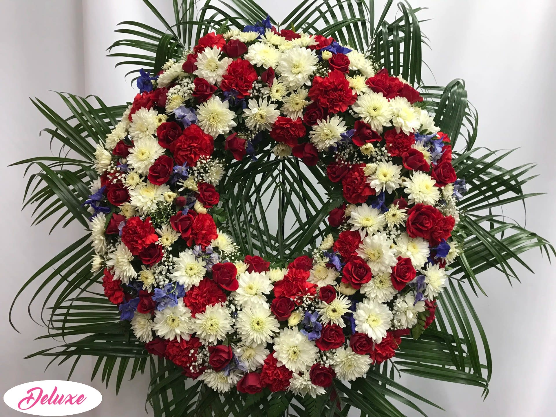 Large red, white, and blue floral wreath with palm fronds