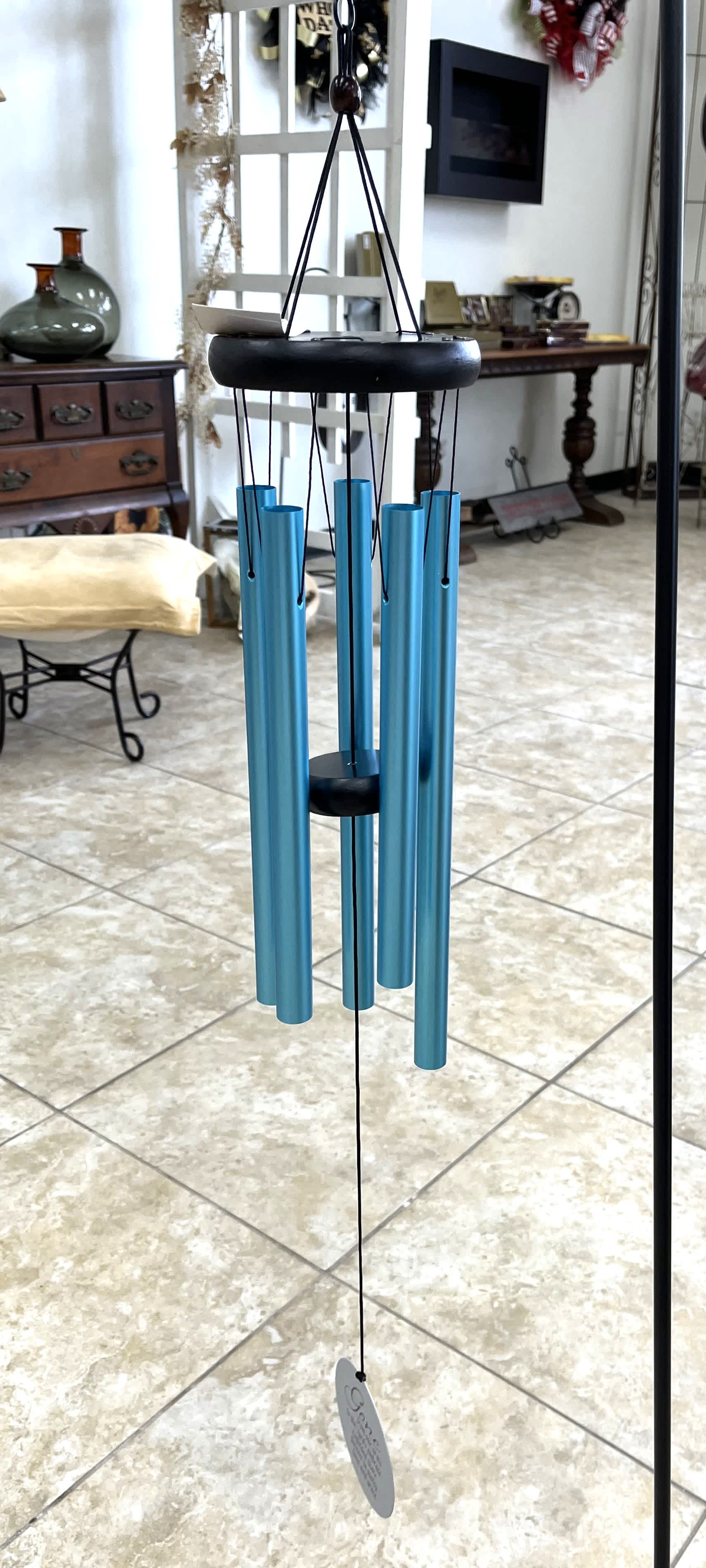 Blue hanging wind chime with black top and clapper
