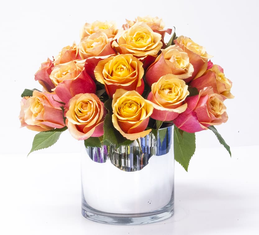 Bouquet of orange and pink roses in a clear glass vase