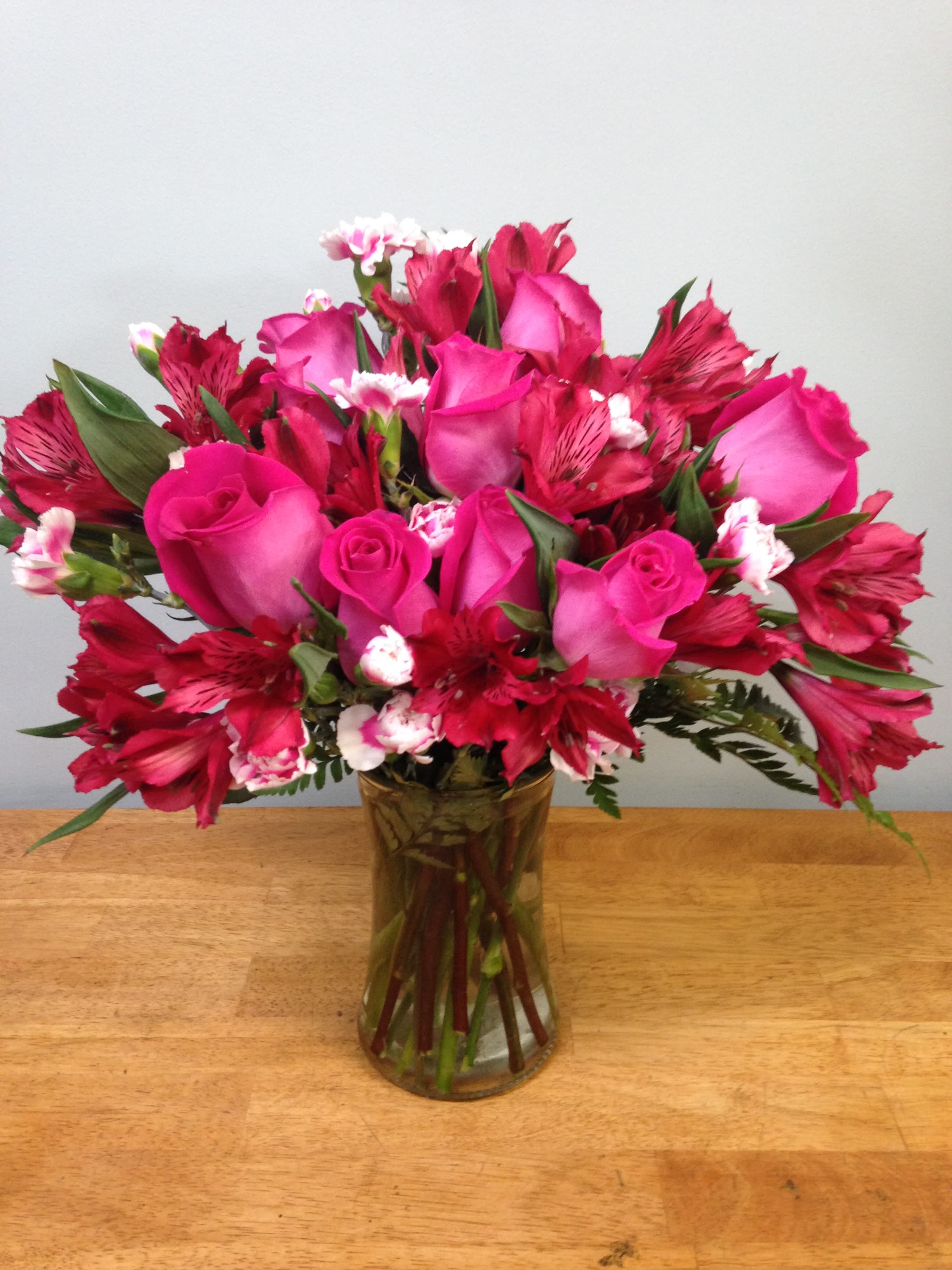 Pink roses and red alstroemeria in a glass vase