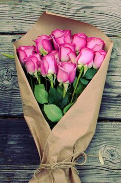 Bouquet of pink roses wrapped in brown paper