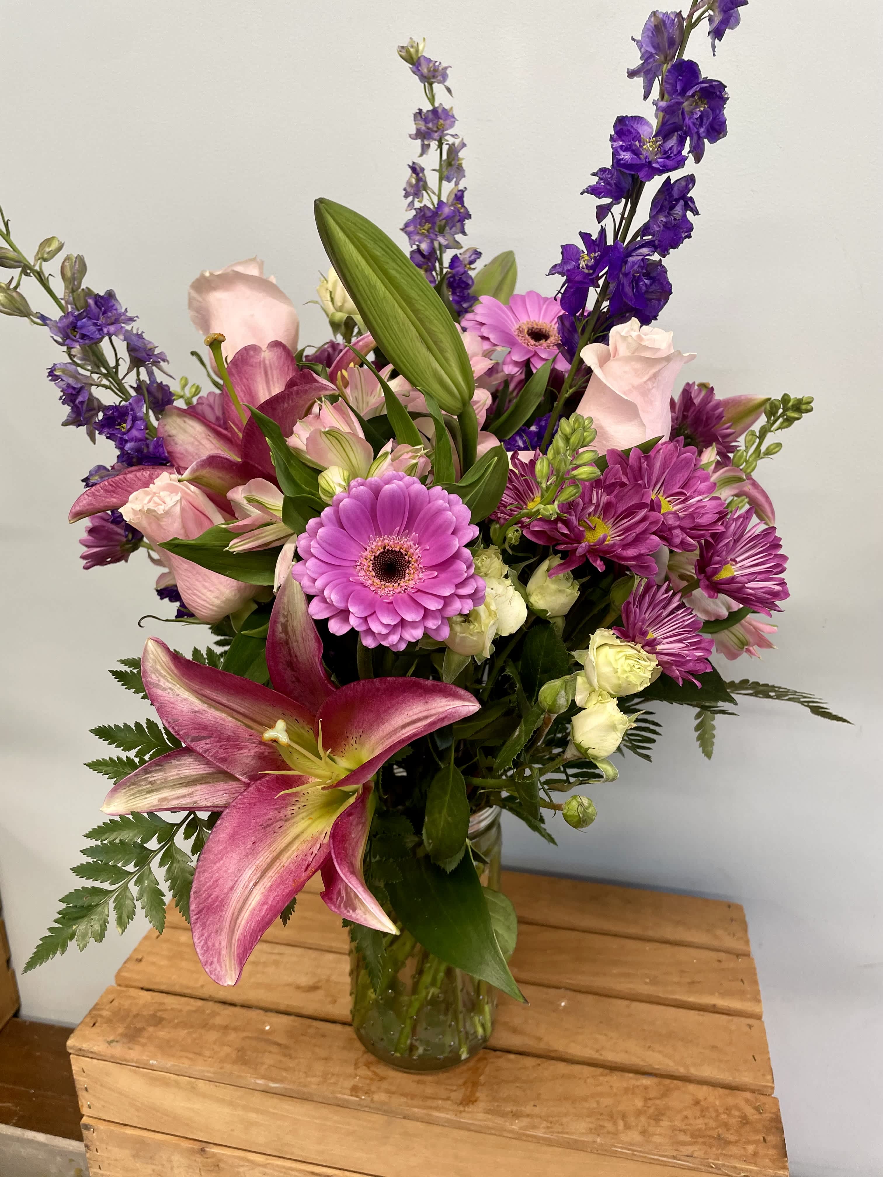Mixed bouquet of pink and purple flowers in a glass vase
