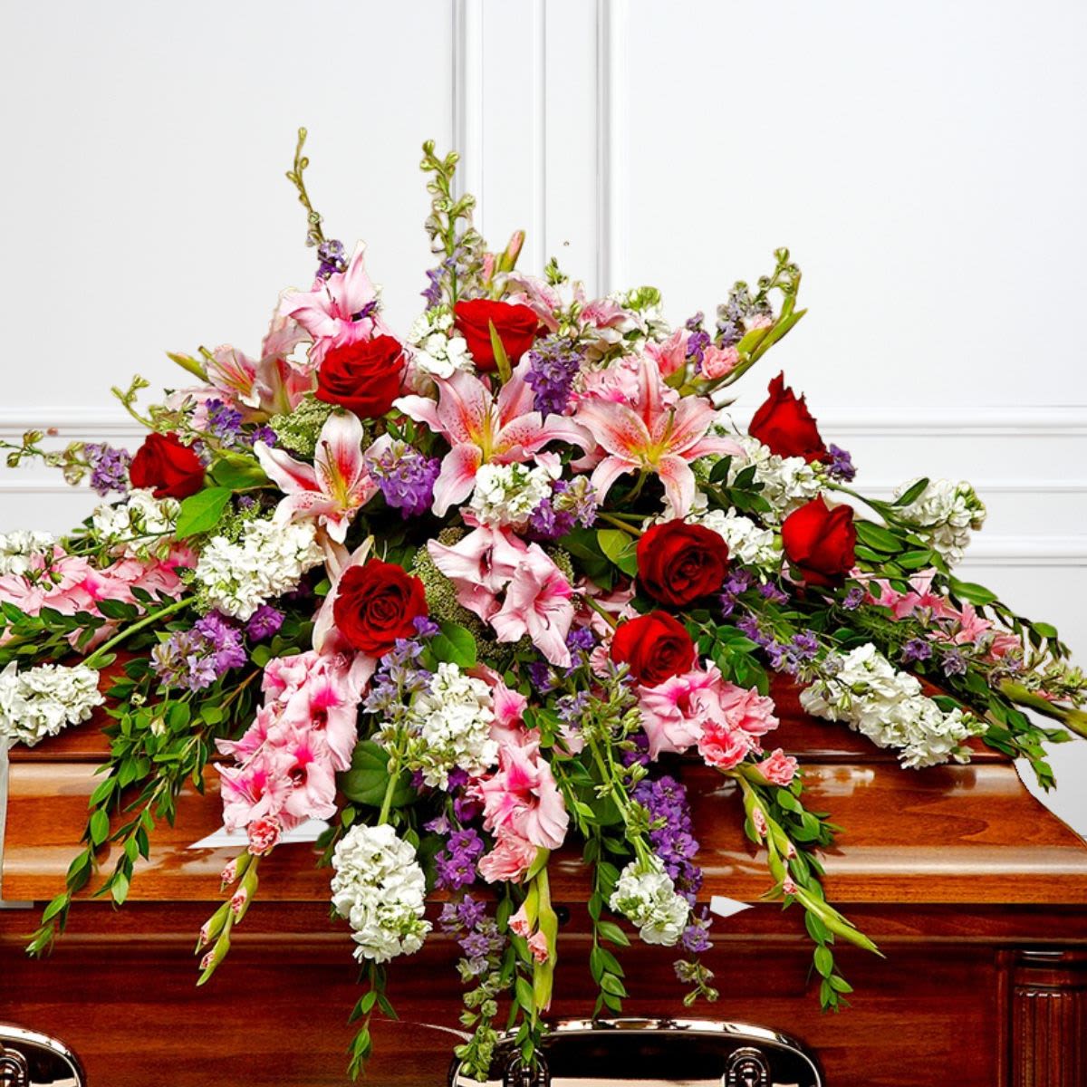 Red, Pink, Lavender, White Half-Size Casket Spray - Shades of pink, white, and lavender, accented with red roses for love, are an expression of sympathy and peace.