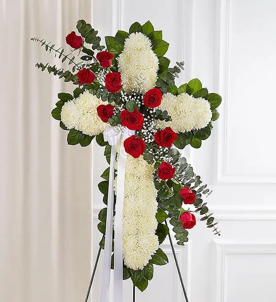 Peace &amp; Prayers - White or Red &amp; White - Standing Cross - Honor a lifetime of faithful devotion with our beautiful standing cross arrangement. Our expert florists handcraft each of these impressive displays with a bed of white mums in the shape of a cross, and accent with a cascade to match. It is a beautiful way to offer peace and comfort during a difficult time.