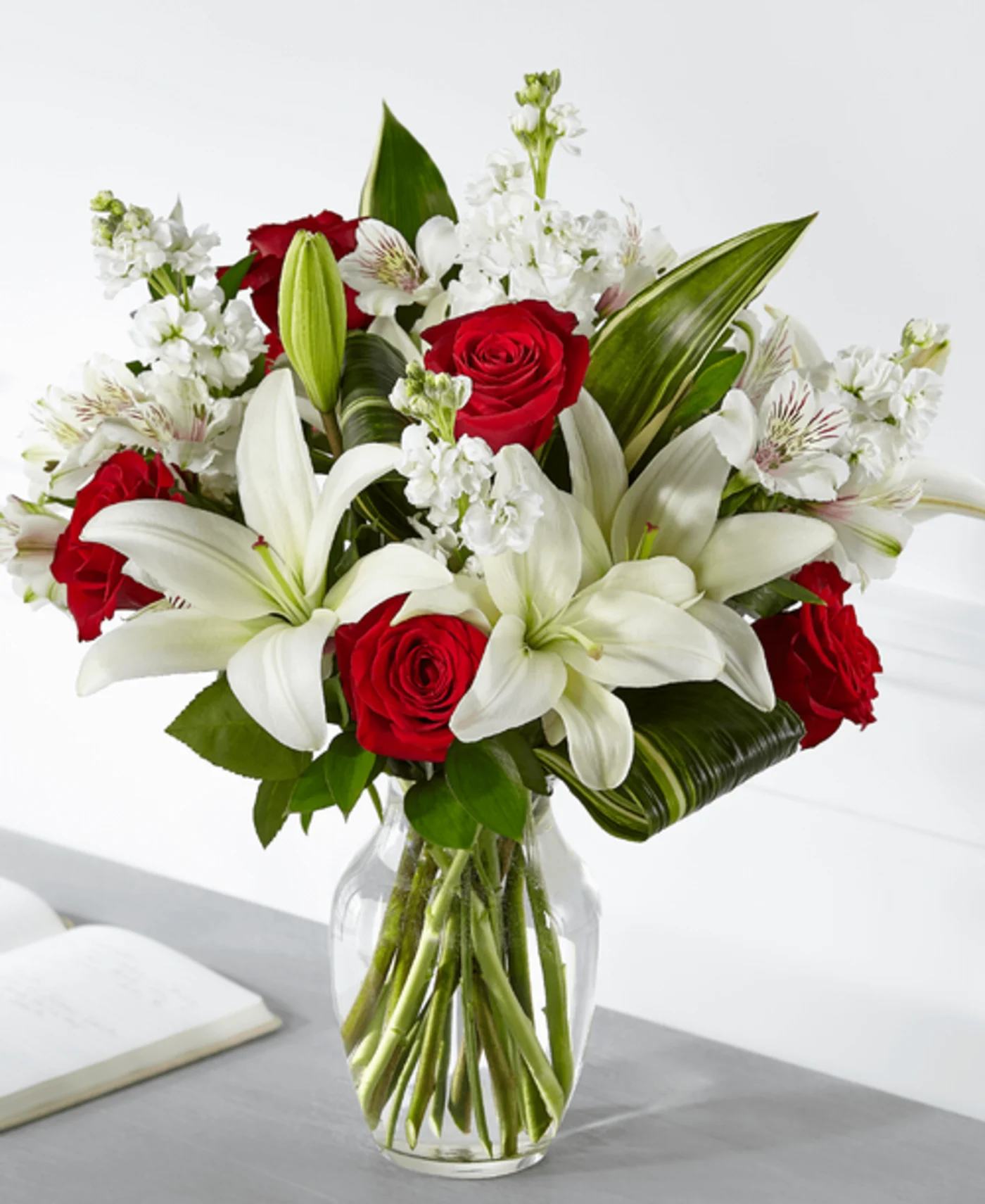 Love And Respect Bouquet - Standard bouquet is approximately 19"H x 15"W. DELUXE bouquet is approximately 19"H x 16"W. Premium bouquet is approximately 20"H x 18"W Item #S5303d. Elegantly crafted with a stunning mix of red and white blooms, our Love and Respect Bouquet reminds those you care about that you are thinking of them. Our local florists design roses and lilies together t convey your comfort and love. *** VASE WILL VARY***