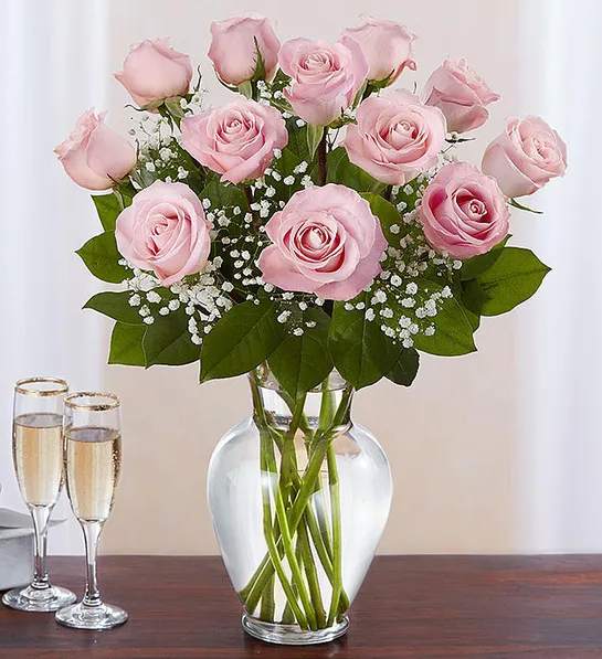 Pink roses arranged in a clear glass vase with baby's breath