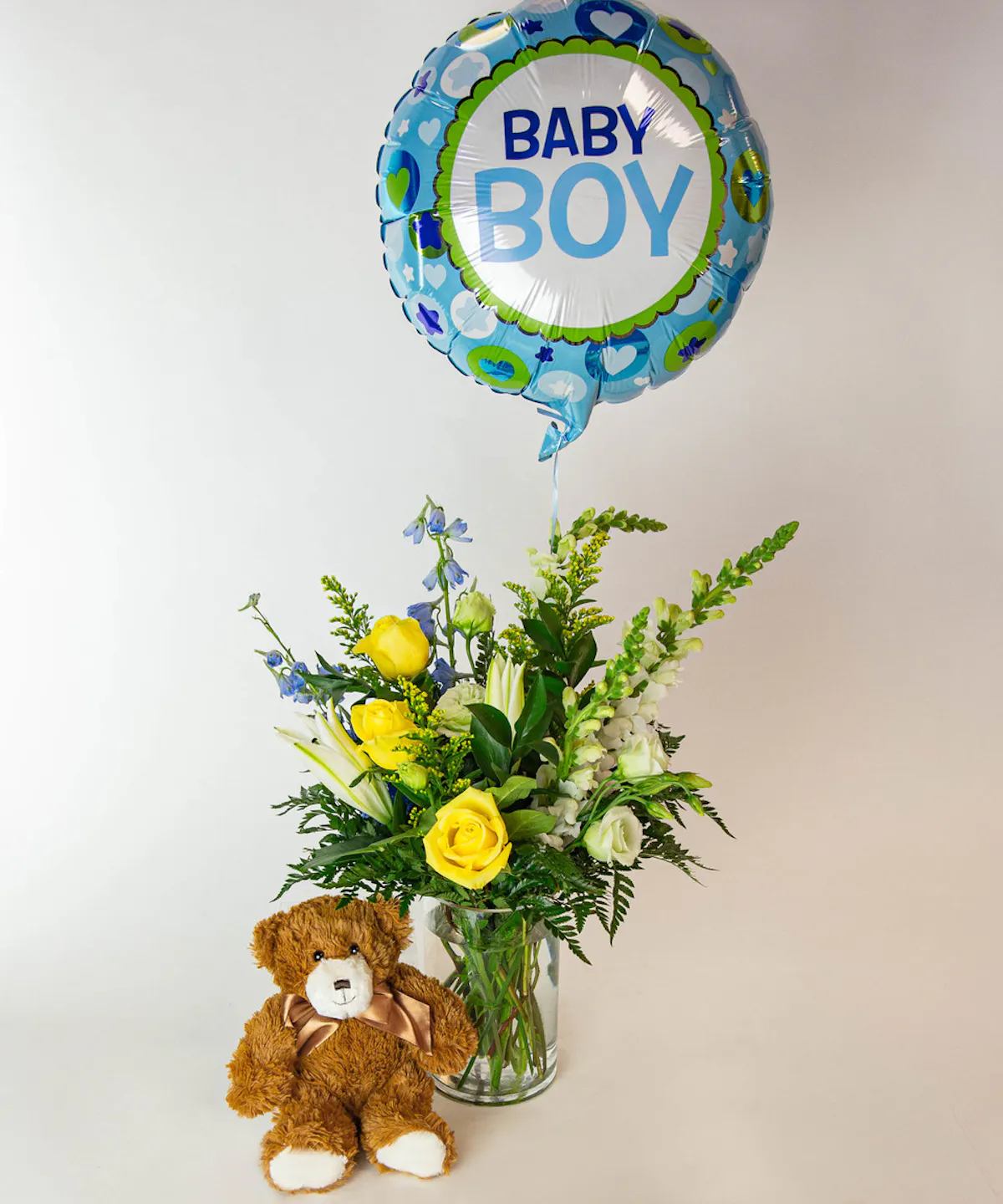 NEW BABY BOY BOUQUET - Welcome the newest bundle of joy with our It's A Boy bundle! We arrange a beautiful bouquet of yellow, blue, and white floral including lilies, snapdragons, roses, and delphinium in a tall cylinder glass vase, then pair it with a plush bear and a baby boy mylar balloon to create the ultimate way to say "welcome new baby!" *** PLEASE NOTE, MYLAR BALLON, TEDDY BEAR DESIGN MAY VARY ****