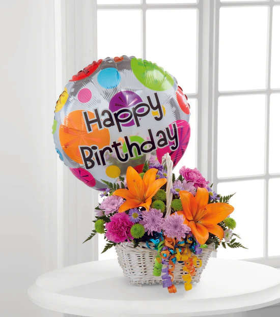 Happy Blooms Basket - Happy Blooms Basket brings together Asiatic lilies and carnations to create the perfect way to send your happy birthday wishes! Orange Asiatic lilies, lavender chrysanthemums, lavender carnations, purple monte casino asters, green button poms and lush greens are beautifully arranged within a rectangular whitewash willow handled basket accented with colorful curling ribbon. Arriving with a bright Mylar balloon exclaiming, "Happy Birthday," this flower arrangement will add to the celebration of their special day. *** BASKET AND BALLOON WILL VARY ***