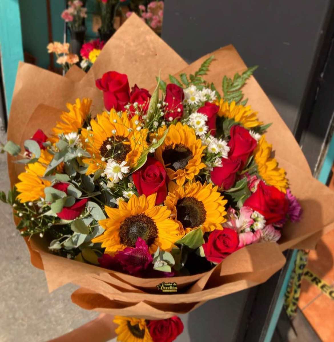 24 Red Roses and Sunflowers in a wrapped bouquet - 24 Red Roses and Sunflowers in a wrapped bouquet with Pink Alstroemeria, White Montecasio, Baby Breath and Eucalyptus Accents. 