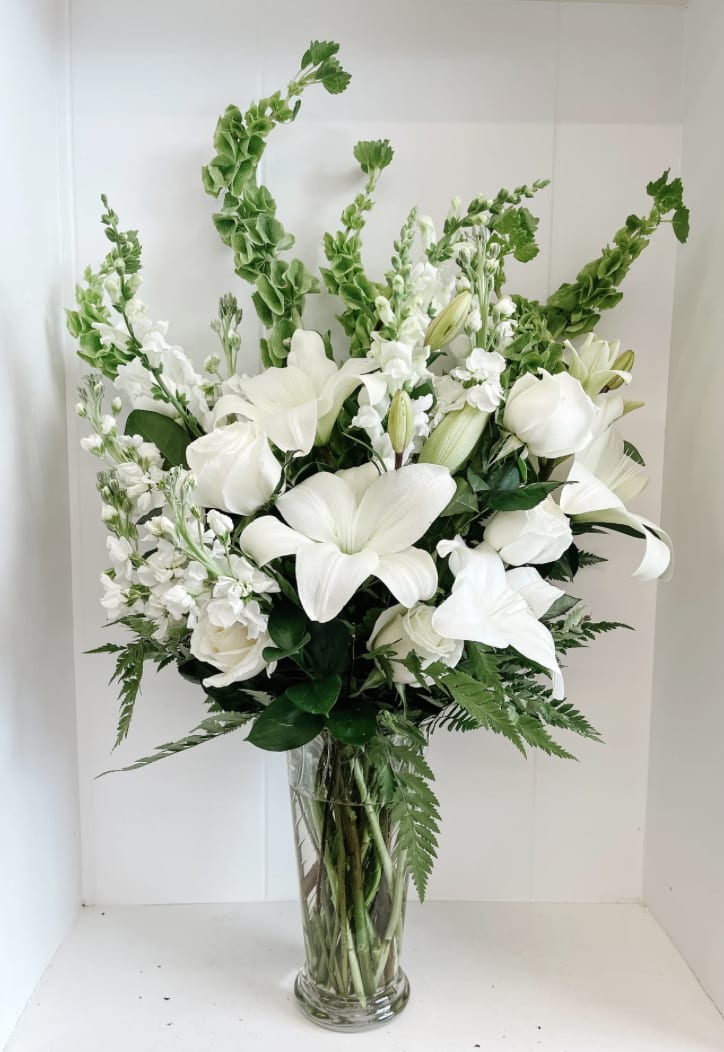 Sweet Sympathy - Calming and refreshing, our sweet sympathy floral arrangement is the appropriate sentiment to express your condolences. Tall, tranquil and full of beautiful blooms including bells of ireland, lilies, snapdragon, stock, and roses. Each of our arrangements are custom designed to order. We will always use the freshest and best looking flowers available. If we cannot complete this design with the flowers shown, we will substitute flowers of equal or greater value.