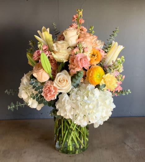 Delicate and Peaceful - Arrangement in vase with a variety of flowers, White Lilies, Yellow Ranunculus, Carnations, Hydrangea and Stock with Eucalyptus accent. 