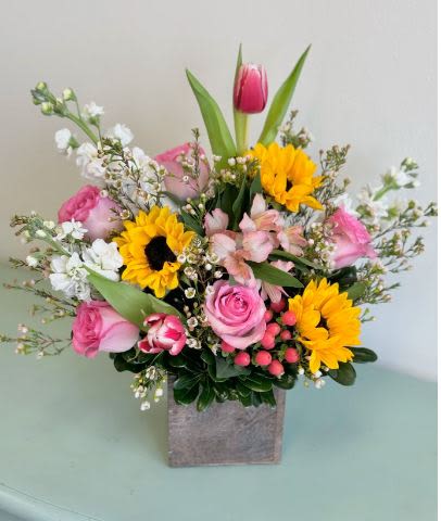 Sunny Garden - This beautiful garden arrangement with Sunflowers, Tulips, Roses and Alstroemeria is sure to put a smile on someone’s face!  Colors will vary depending on the season availability. 